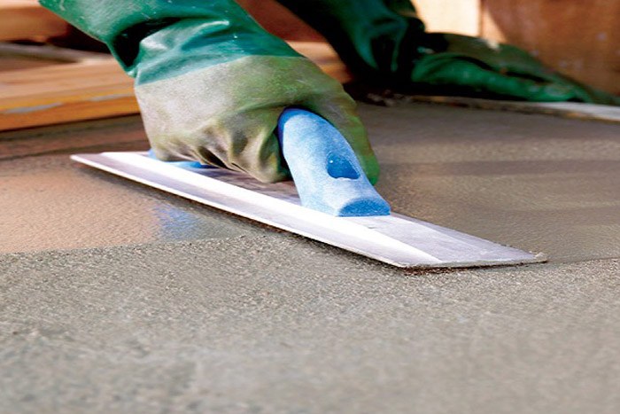 Person Smoothing Out Concrete With Tool