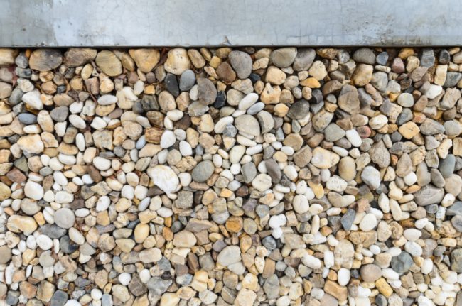 A decorative rock landscaping replacing traditional grass lawns by Sandee's Soil and Rock